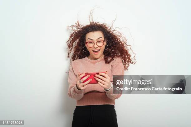 amazed woman using phone - dyed red hair fotografías e imágenes de stock