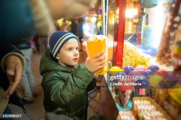 little boy with popcorn at christmas market - christmas town stock pictures, royalty-free photos & images