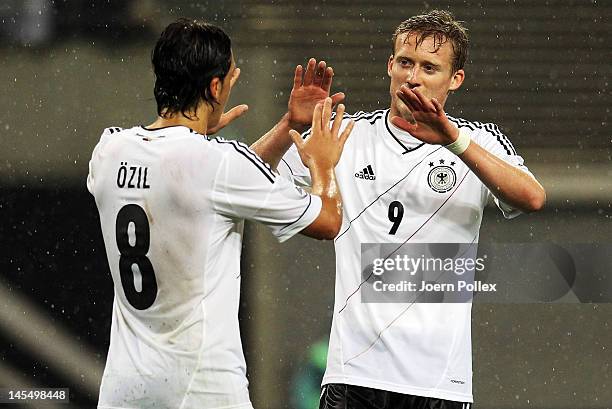 Andre Schuerrle of Germany celebrates with his team mate Mesut Oezil after scoring his team's second goal during the international friendly match...