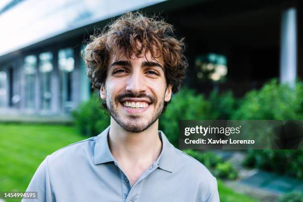 close-up portrait of young hipster smiling cheerful man smiling at camera outside - männer portrait gesicht close up stock-fotos und bilder