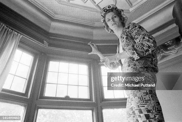 English singer, musician and actor David Bowie paints the coving of his ground floor flat at Haddon Hall in silver paint, Beckenham, south-east...