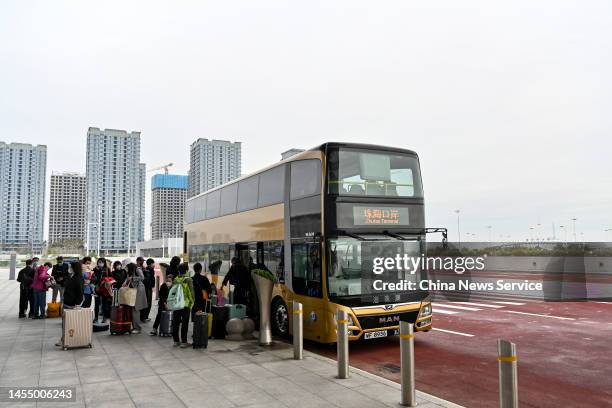 Travellers get off a shuttle bus after arriving at Hong Kong-Zhuhai-Macao Bridge Zhuhai Port as China further optimizes its regulations on travel...