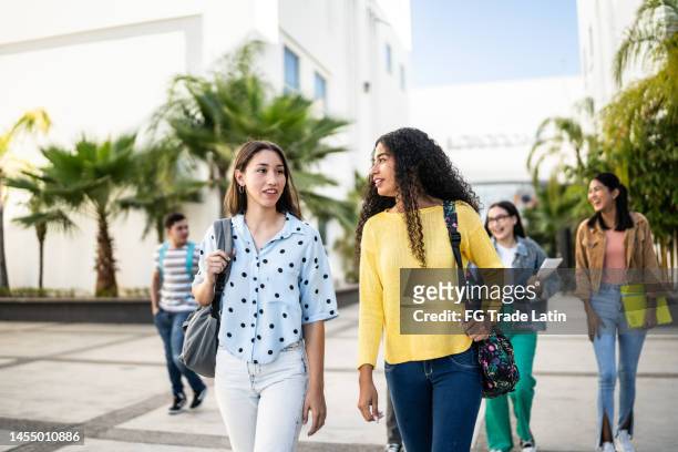 young friends talking while arriving at university - public school building stock pictures, royalty-free photos & images