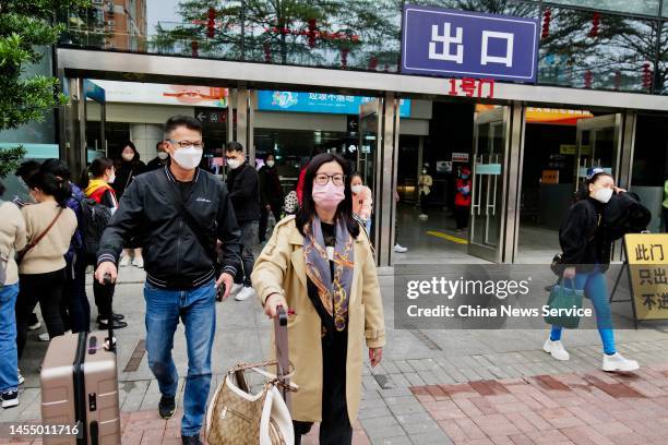 Travellers with their luggage walk out of the Futian Port between mainland China and Hong Kong as China further optimizes its regulations on travel...