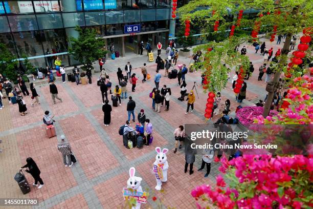 Travellers with their luggage walk out of the Futian Port between mainland China and Hong Kong as China further optimizes its regulations on travel...