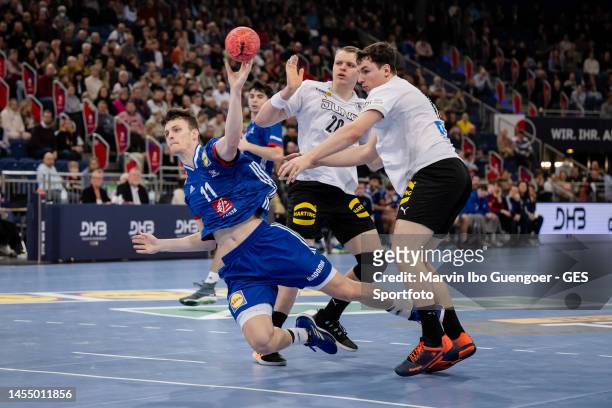 Alexis Berthier of France throws a ball and is tackled by Justus Fischer and Christian Wilhelm of Germany during the U21 handball international...