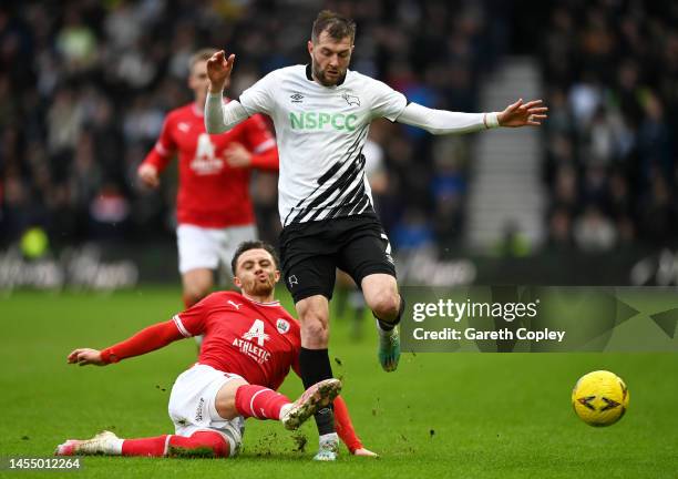 Jordan Williams of Barnsley tackles Tom Barkhuizen of Derby County during the Emirates FA Cup Third Round match between Derby County and Barnsley at...