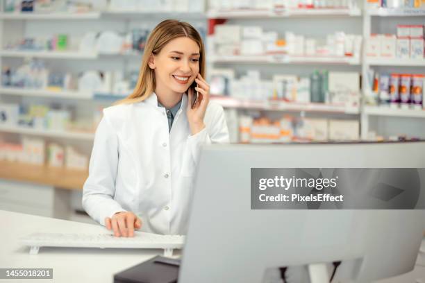 female pharmacist talking on the phone - pharmacist phone stock pictures, royalty-free photos & images