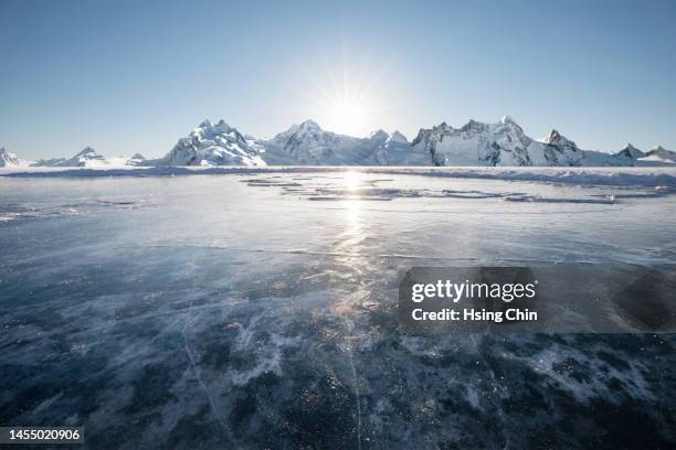 frozen lakes and snow mountains - snow covered road stock-fotos und bilder