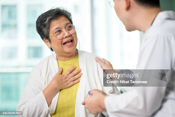 to keep the heart unwrinkled in the elderly citizens. an asian senior patient is talking and laughing with a male doctor about general things about daily life while a male doctor comforting her during a home visit. - doctor emoticon stock pictures, royalty-free photos & images