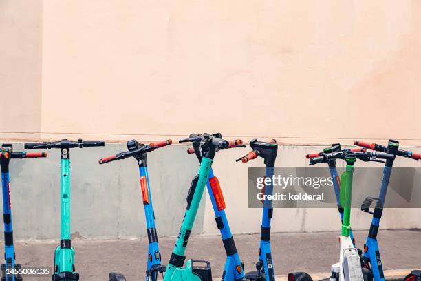 push scooters against peach colored wall - step stockfoto's en -beelden