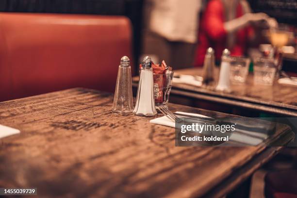 empty tables in parisian bistro, close-up - salt shaker stock pictures, royalty-free photos & images