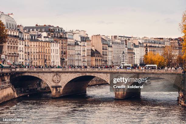 autumn in paris, seine river, pont neuf with traffic and tourists - pont neuf stock pictures, royalty-free photos & images