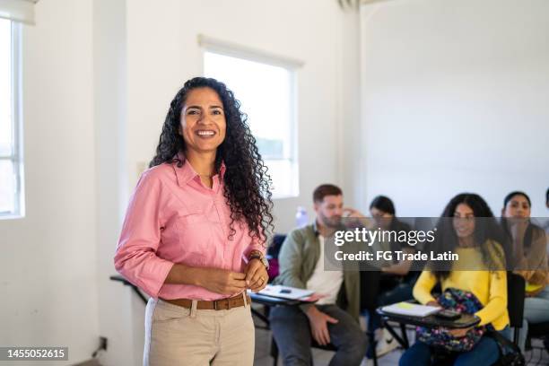 portrait of a mid adult teacher in the classroom at university - academia stockfoto's en -beelden