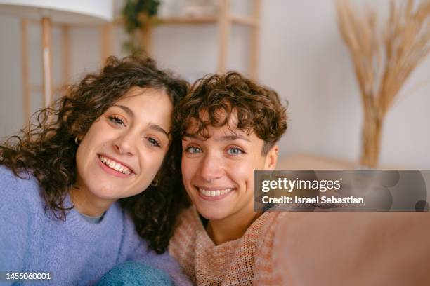 selfie of a pretty lesbian couple smiling while looking at the camera. - girlfriends stock pictures, royalty-free photos & images