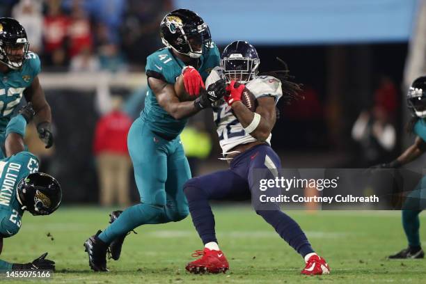 Derrick Henry of the Tennessee Titans is tackled by Josh Allen of the Jacksonville Jaguars during the second half at TIAA Bank Field on January 07,...