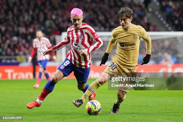 Gavi of FC Barcelona is challenged by Antoine Griezmann of Atletico Madrid during the LaLiga Santander match between Atletico de Madrid and FC...