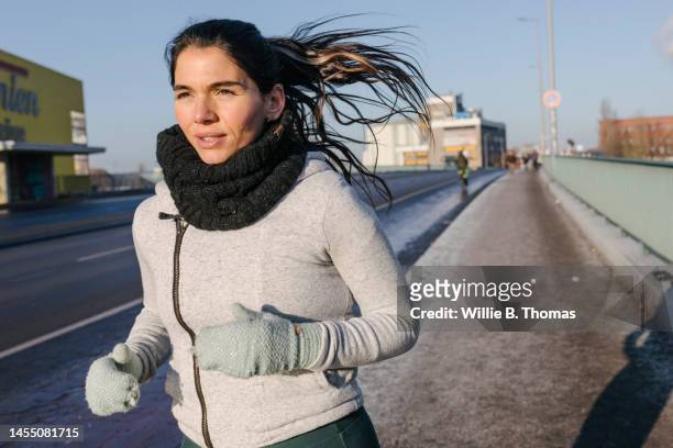 one woman running on a chilly day - runners stock pictures, royalty-free photos & images