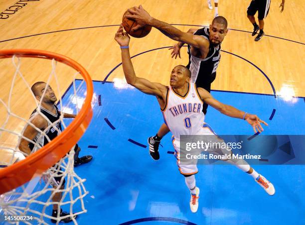 Russell Westbrook of the Oklahoma City Thunder goes up for the shot as Tim Duncan of the San Antonio Spurs attempts to block it from behind in the...