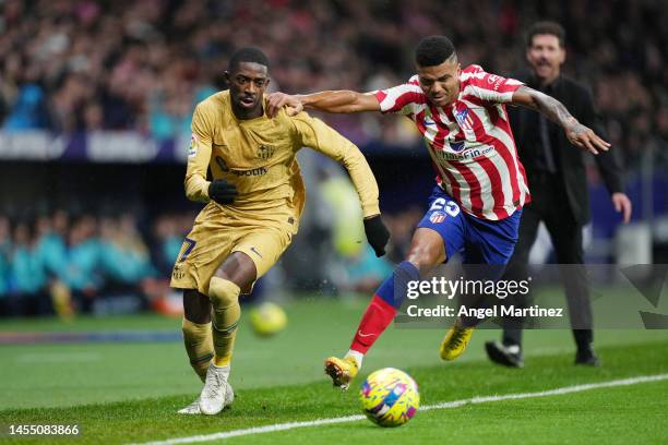 Ousmane Dembele of FC Barcelona is challenged by Reinildo Mandava of Atletico Madrid during the LaLiga Santander match between Atletico de Madrid and...