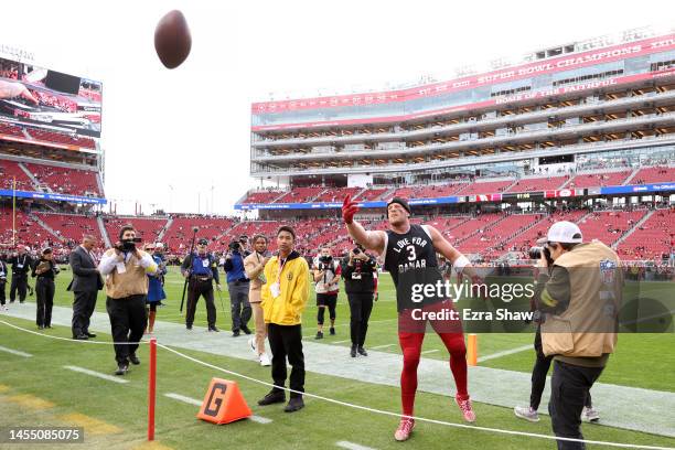 Watt of the Arizona Cardinals tosses a ball to a fan as he wears a t-shirt honoring Damar Hamlin of the Buffalo Bills prior to the game against the...