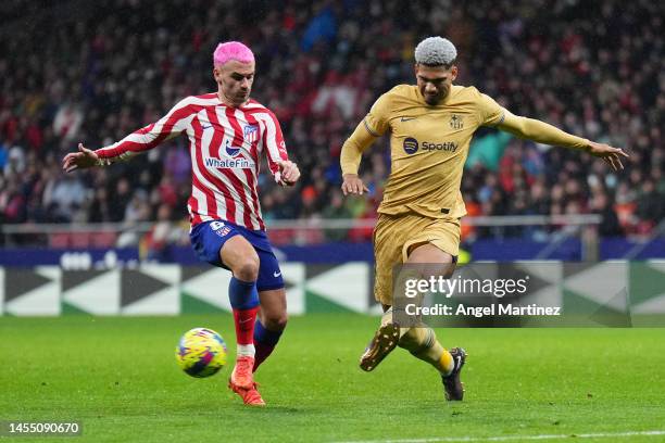 Ronald Araujo of FC Barcelona is challenged by Antoine Griezmann of Atletico Madrid during the LaLiga Santander match between Atletico de Madrid and...