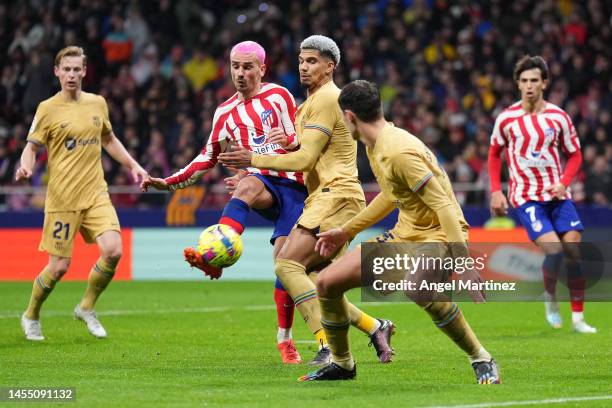 Antoine Griezmann of Atletico Madrid is challenged by Ronald Araujo of FC Barcelona during the LaLiga Santander match between Atletico de Madrid and...