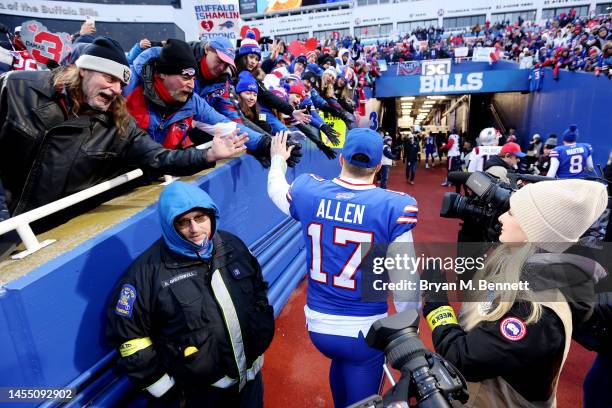 Josh Allen of the Buffalo Bills high fives fans after Buffalo's 35-23 win against the New England Patriots at Highmark Stadium on January 08, 2023 in...