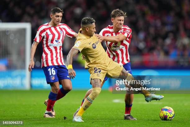 Raphinha of FC Barcelona battles for possession with Marcos Llorente of Atletico Madridduring the LaLiga Santander match between Atletico de Madrid...