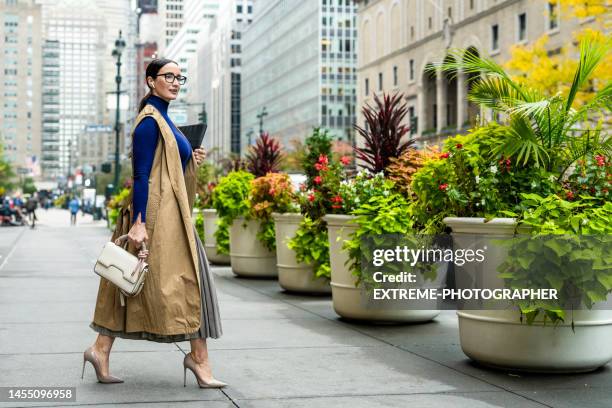 gut gekleidete geschäftsfrau beim verlassen des gebäudes in manhattan nach der arbeit - eleganter schuh stock-fotos und bilder