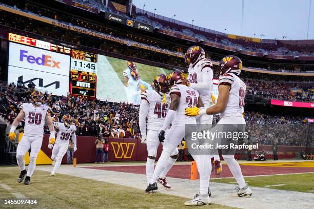 The Washington Commanders celebrate after Milo Eifler of the Washington Commanders completes a play during the first half of the game against the...