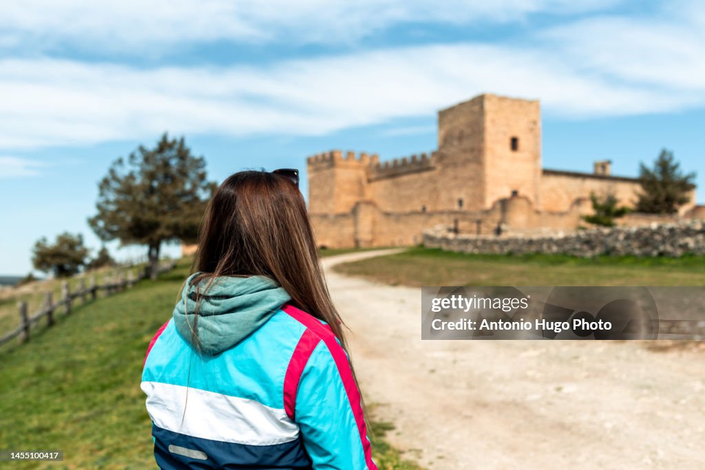 Rear view of a Young blonde woman in the castle of Pedraza, Segovia.