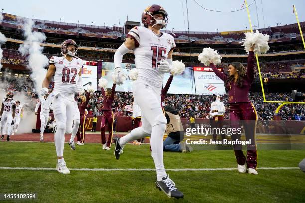 Dax Milne and Logan Thomas of the Washington Commanders walk onto the field prior to the game against the Dallas Cowboys at FedExField on January 08,...