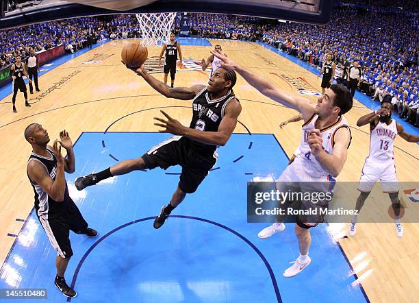 Kawhi Leonard of the San Antonio Spurs goes up for a layup against Nick Collison of the Oklahoma City Thunder in Game Three of the Western Conference...