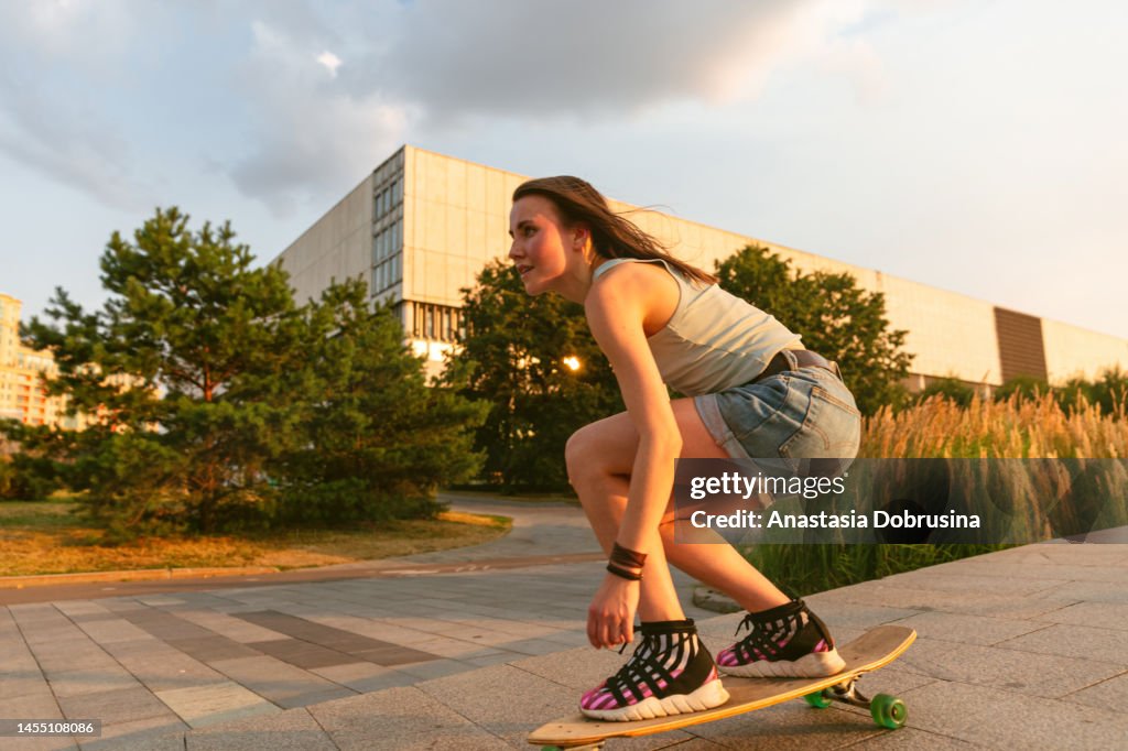 Frau reitet bei Sonnenuntergang auf Longboard
