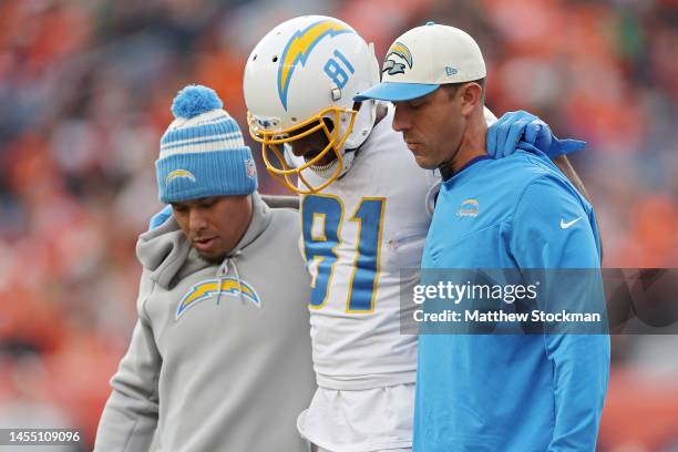 Trainers assist Mike Williams of the Los Angeles Chargers off the field during the first half against the Denver Broncos at Empower Field At Mile...