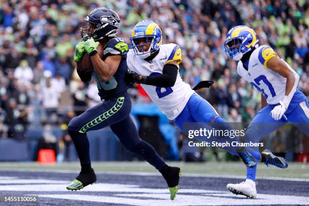 Tyler Lockett of the Seattle Seahawks catches a pass over Troy Hill of the Los Angeles Rams for a touchdown during the third quarter at Lumen Field...