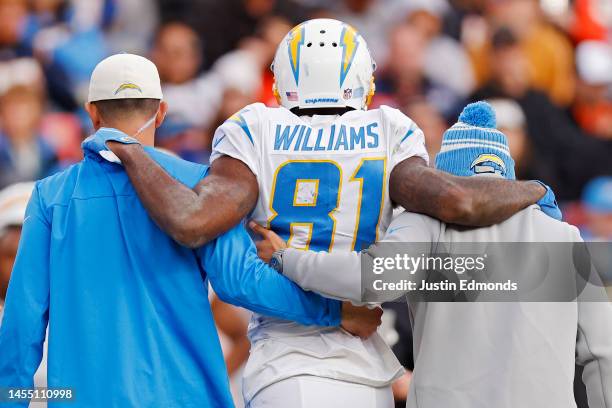 Trainers assist Mike Williams of the Los Angeles Chargers off the field during the first half against the Denver Broncos at Empower Field At Mile...