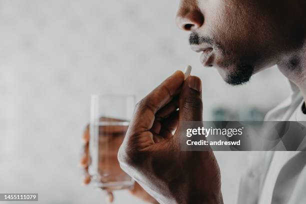 mann, der sich selbst in der häuslichen medizin behandelt - antibiotic stock-fotos und bilder