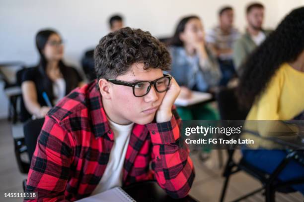 bored young man watching class at university - angry boy stockfoto's en -beelden