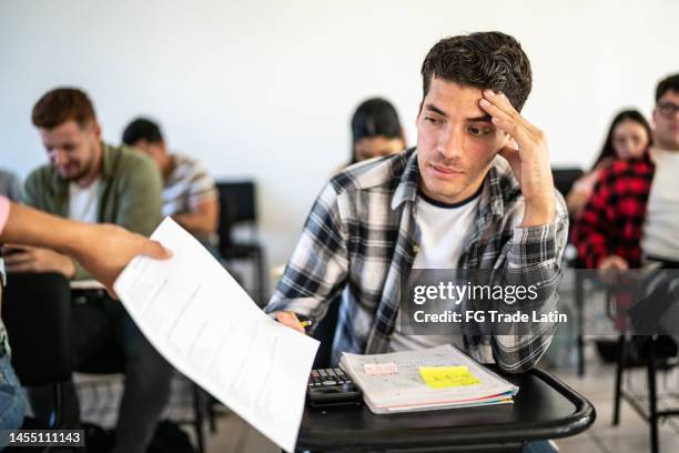 young man receiving his test result in the classroom at university - failure stock pictures, royalty-free photos & images