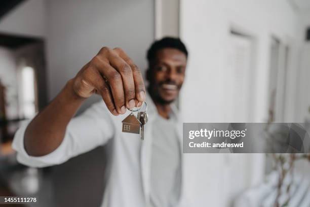 man holding new house key - home ownership keys stock pictures, royalty-free photos & images