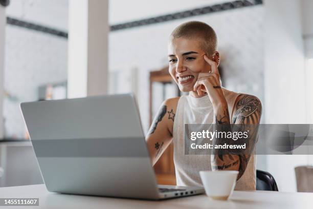 retrato de mujer usando una computadora portátil en su hogar - hipster professional fotografías e imágenes de stock