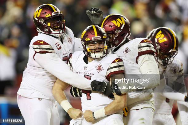 Sam Howell of the Washington Commanders celebrates after scoring a touchdown in the third quarter of the game against the Dallas Cowboys at...