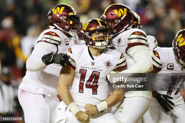 Sam Howell of the Washington Commanders celebrates after scoring a touchdown in the third quarter of the game against the Dallas Cowboys at...