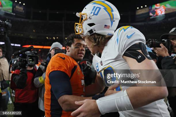 Russell Wilson of the Denver Broncos and Justin Herbert of the Los Angeles Chargers shake hands after Denver's 31-28 win at Empower Field At Mile...