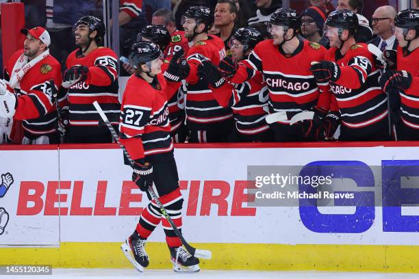 Lukas Reichel of the Chicago Blackhawks celebrates with teammates after scoring his first career NHL goal against the Calgary Flames during the first...