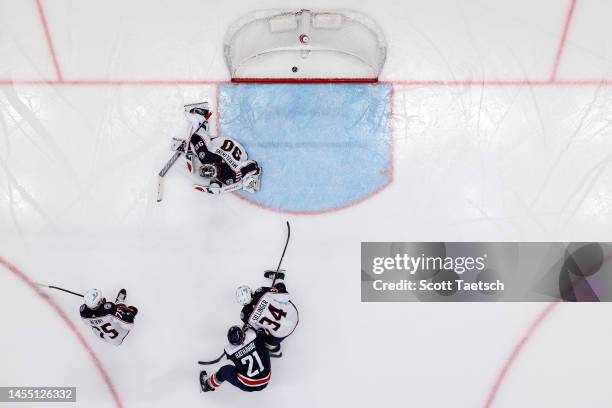 Garnet Hathaway of the Washington Capitals fights for position as Erik Gustafsson scores a goal against Elvis Merzlikins of the Columbus Blue Jackets...