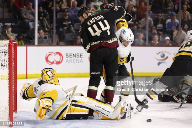 Goaltender Casey DeSmith of the Pittsburgh Penguins makes a save on the puck as Zack Kassian of the Arizona Coyotes looks for a rebound during the...