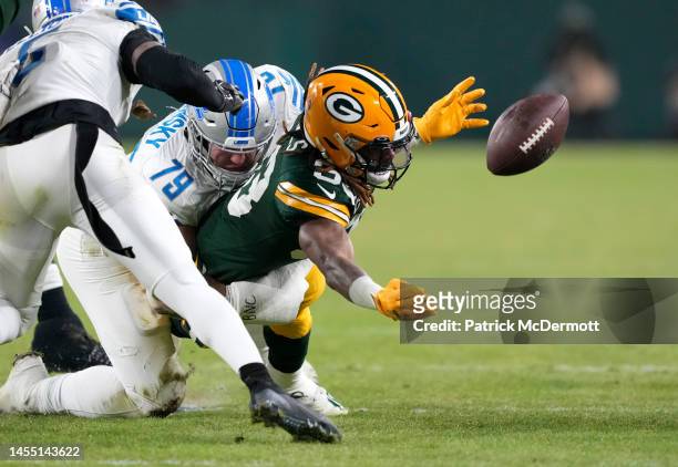 John Cominsky of the Detroit Lions forces a fumble by Aaron Jones of the Green Bay Packers during the second quarter at Lambeau Field on January 08,...